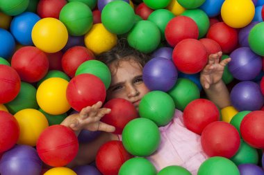 Kız eğleniyor renkli plastik top havuzunda oynayan