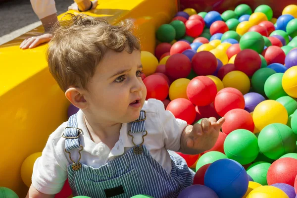 Дитячий хлопчик весело грає в барвистому пластиковому басейні — стокове фото