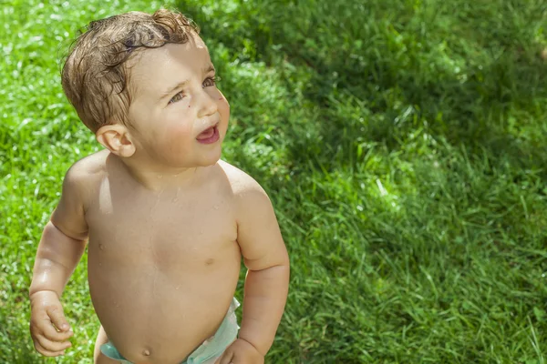 Fechar menino brincando com água no jardim . — Fotografia de Stock