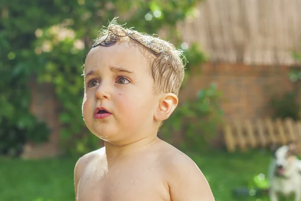 Close up retrato menino brincando com água no jardim . — Fotografia de Stock