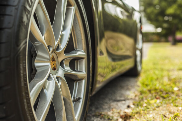 Extreme close up shot wheel with trademark of a Porsche Cayman.