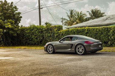 Genç bir adamın bir Porsche Cayman sürüş düşük ihtimal. Kentsel sahne.