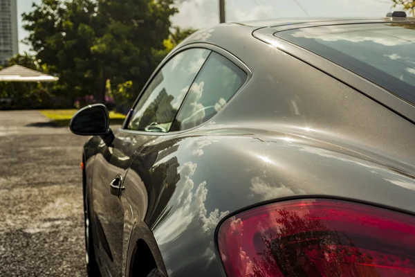 Close up shot sideways of a Porsche Cayman. Urban scene. — Stock Photo, Image