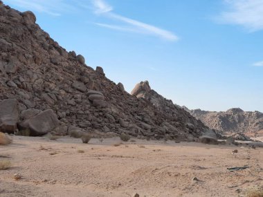 Suudi Arabistan 'ın Tabuk kentindeki ünlü Split Rock oluşum bölgesinin çarpıcı bir görüntüsü. Bu doğal kumtaşı yapısı eşsiz dikey bölünmesi ve manzaralı çöl çevresiyle bilinir..