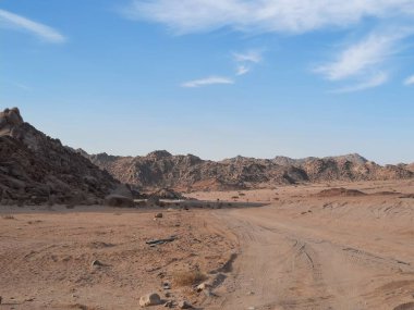 Suudi Arabistan 'ın Tabuk kentindeki ünlü Split Rock oluşum bölgesinin çarpıcı bir görüntüsü. Bu doğal kumtaşı yapısı eşsiz dikey bölünmesi ve manzaralı çöl çevresiyle bilinir..