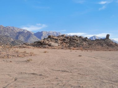 Suudi Arabistan 'ın Tabuk kentindeki ünlü Split Rock oluşum bölgesinin çarpıcı bir görüntüsü. Bu doğal kumtaşı yapısı eşsiz dikey bölünmesi ve manzaralı çöl çevresiyle bilinir..
