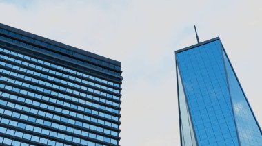 Soluk gökyüzüne karşı iki modern cam cepheli gökdelenin alçak açılı 3D görüntüsü, kurumsal iş geçmişleri için ideal. Yatay pencere bölümleri olan dikdörtgen bir bina ve koyu mavi yansıtıcı camla daha uzun, daha ince bir bina..