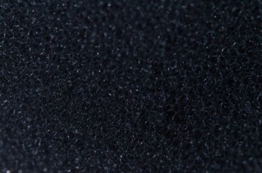 Koyu, tanecikli ve çaktırmadan yansıtan soyut doku çerçeveyi doldurur. Üniforması, düzensiz parçacık bileşimi metin için yumuşak odaklı mükemmel bir kopya alanı sunar.