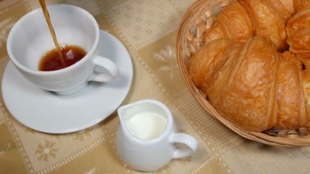 Verter café en la taza con Croissant — Vídeo de stock