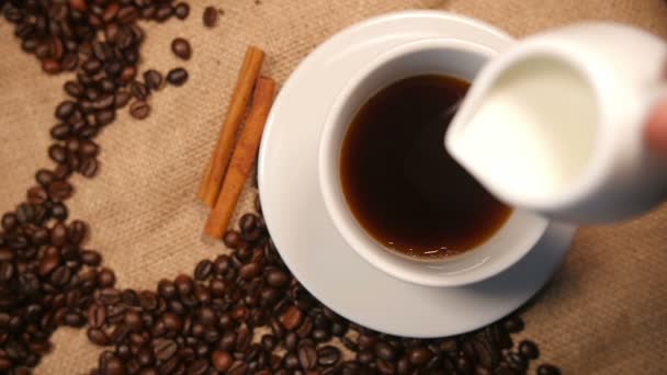 Выливание молока в кофе — стоковое видео