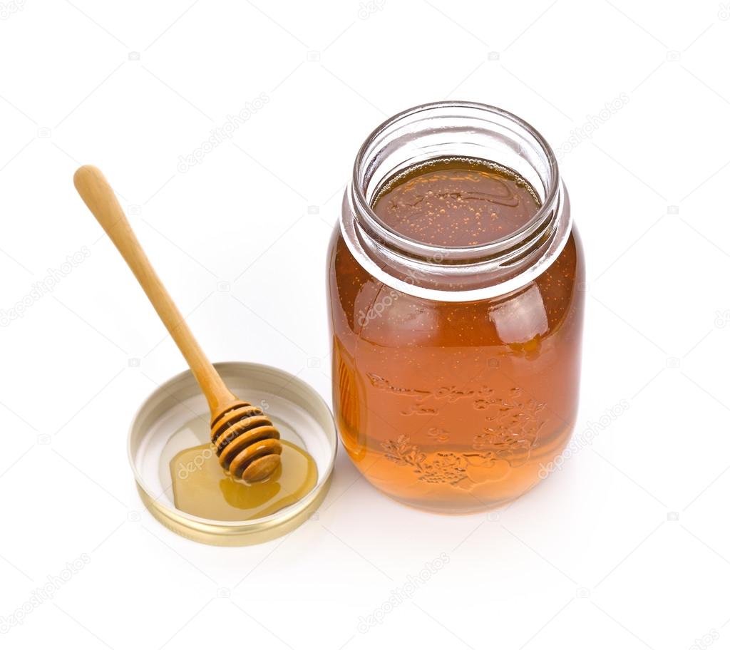 honey dipper and honey in jar on white background