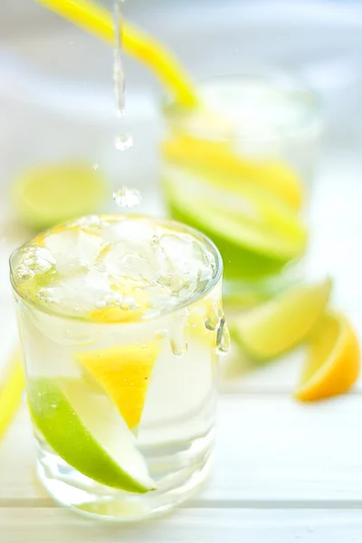 Коктейль з лимоном і лаймом у склянці з бризками води — стокове фото