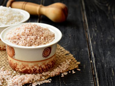 Bir fincan koyu arka plan üzerinde beyaz ve kahverengi pirinç