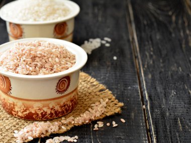 Bir fincan koyu arka plan üzerinde beyaz ve kahverengi pirinç