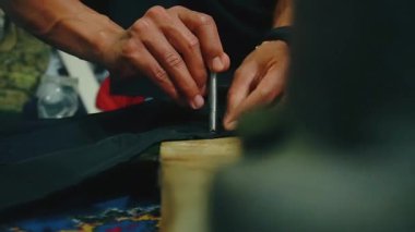 Bir insanın eli bir cekete elle düğme takar.