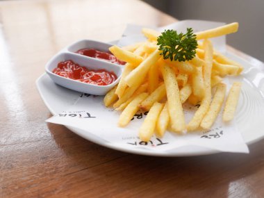 Bandung, Endonezya - 16 Ekim 2025; Lezzetli patates kızartması domates sosu ve acı biber sosuyla servis edildi