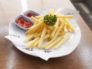 Bandung, Endonezya - 16 Ekim 2025; Lezzetli patates kızartması domates sosu ve acı biber sosuyla servis edildi