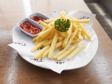 Bandung, Endonezya - 16 Ekim 2025; Lezzetli patates kızartması domates sosu ve acı biber sosuyla servis edildi