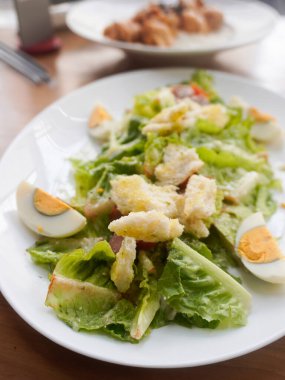 Çıtır marul, yumurta, füme sığır eti, kıtır kıtır kızarmış ekmek, parmesan peyniri ve hafif Sezar soslu ev yapımı Sezar salatası.