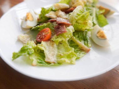 Çıtır marul, yumurta, füme sığır eti, kıtır kıtır kızarmış ekmek, parmesan peyniri ve hafif Sezar soslu ev yapımı Sezar salatası.