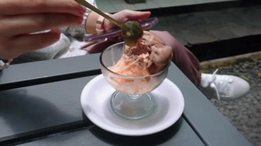 Katmanlı taze portakallı ve çikolatalı dondurmanın tadını çıkarıyorum.