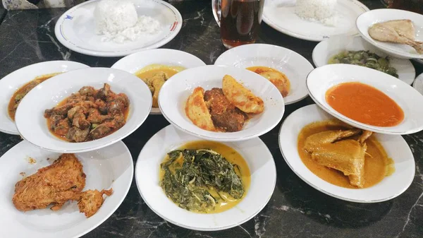 Tavuk köri, ızgara tavuk, kurutulmuş et, karaciğer ve taşlık gibi çeşitli menü seçenekleri olan bir yığın tabak.