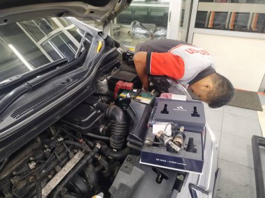 Bandung, Endonezya - 8 Aralık 2025; Bir tamirci arabanın farlarına LED lambalar takıyor