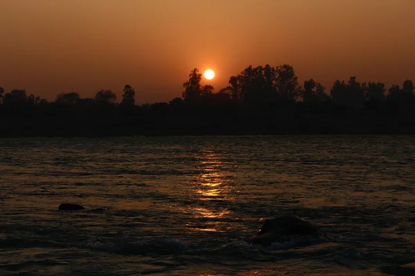 Puesta de sol en el sagrado río indio Ganga. Rishikesh, India del Norte . — Foto de Stock
