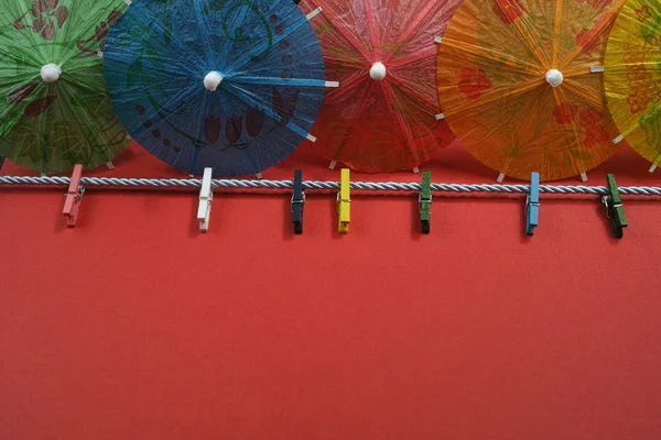 Colorful washline with clothespins and paper umbrellas, copy spa — Stock Photo, Image