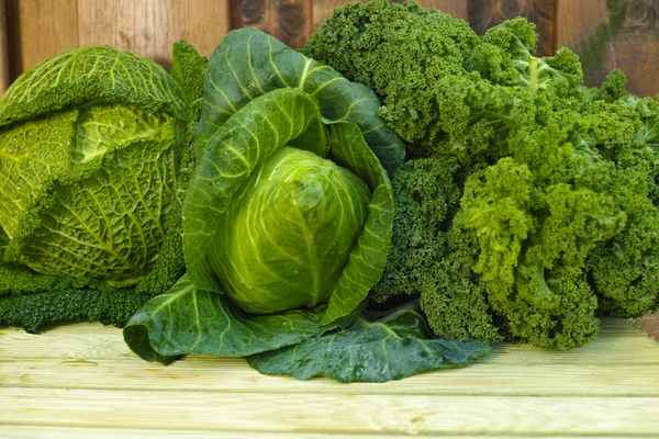 Fresh green organic market vegetables on wooden background