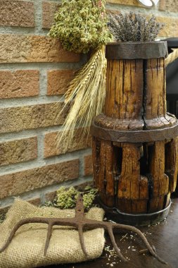Antique pitchfork and wooden wheel hub on burlap sack against ru