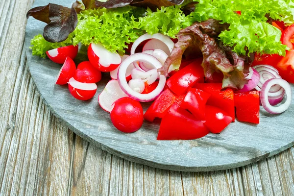 Wooden plate with mixed ingredients for fresh vegetable salad — Stockfoto