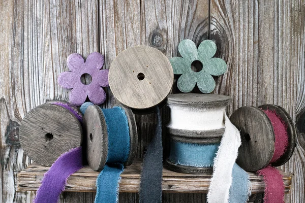 Carretes de madera coloridos con cintas de lino sobre fondo de madera — Foto de Stock