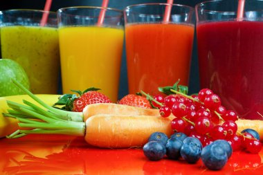 Colofrul fresh pressed fruit juices in tall glasses with fruits