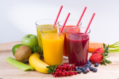 Colofrul fresh pressed fruit juices in tall glasses with fruits