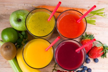 Colofrul fresh pressed fruit juices in tall glasses with fruits