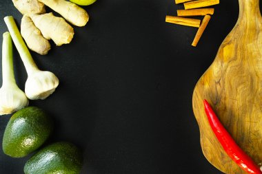 Taze zencefil, sarımsak, avokado ve siyah arka plan üzerine baharat