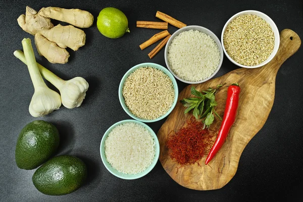 Cuencos con diferentes tipos de arroz, verduras y especias — Foto de Stock