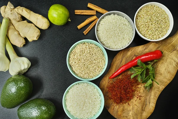 Cuencos con diferentes tipos de arroz, verduras y especias — Foto de Stock