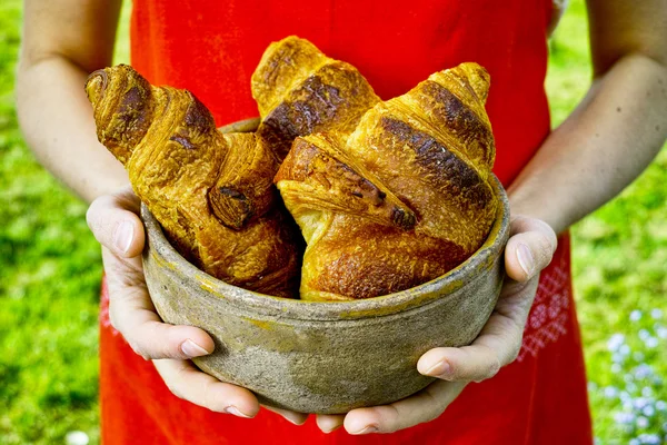 Jeune femme tenant une assiette de croissants frais cuits au four — Photo