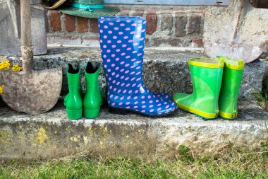 Bahçe ekipmanları - lastik çizmeler, kürek ve güneşli günde hasır şapkalar