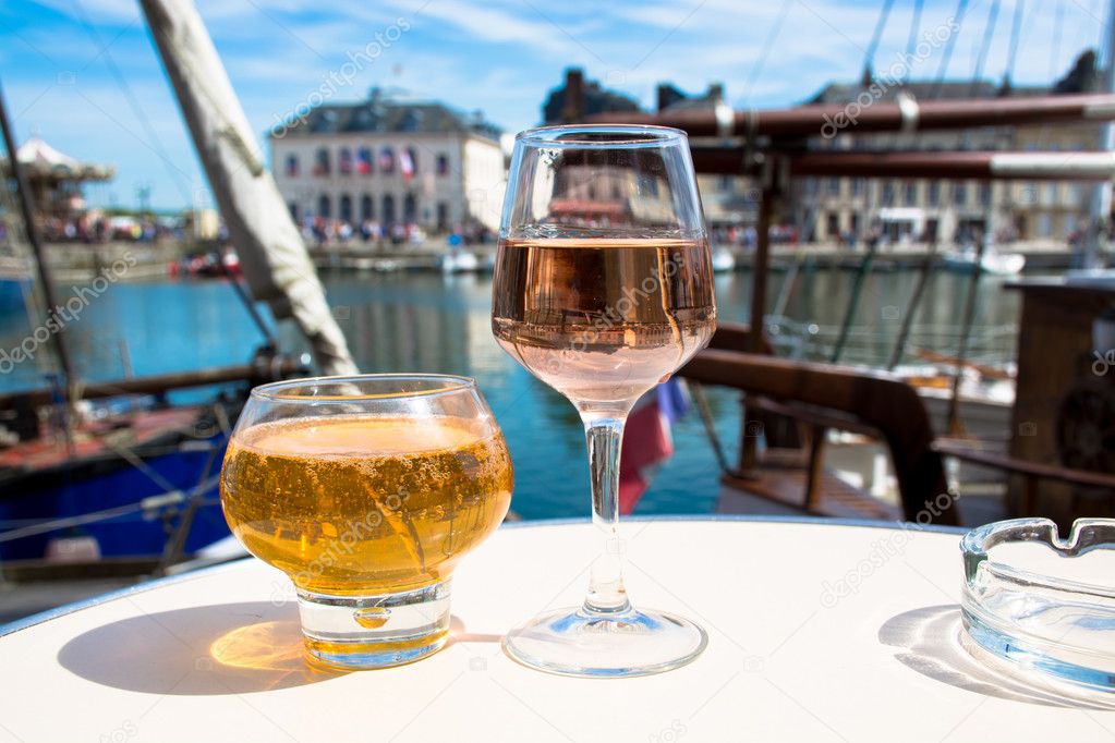 Glass with tasty apple cider and rose vine in old French fisherm