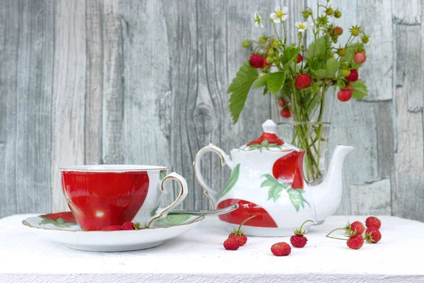 Fresh wild strawberry tea and bouquet of ripe wild strawberries