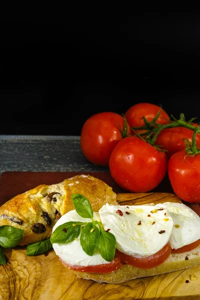 Vytváření zdravých vegetariánských vegetarián sendvič s rajčaty, bazalkou, mozzarellou — Stock fotografie