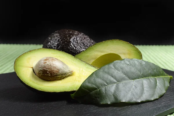 Avocat bio mûr frais sur fond vert et noir — Photo