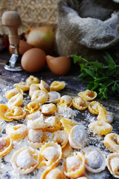 Domácí těstoviny ravioli na starý dřevěný stůl s moukou, vejci, kit — Stock fotografie