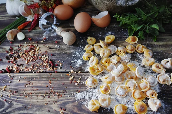 Raviolis de pasta casera sobre mesa de madera vieja con harina, huevos, kit —  Fotos de Stock