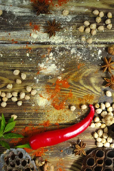 Kleurrijk voedsel achtergrond - kikkererwten en kruiden op geweven hout — Stockfoto