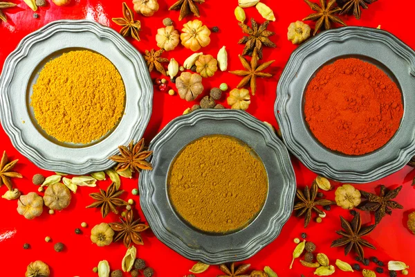 Kolorowe indyjskie przyprawy na czerwonym tle — Zdjęcie stockowe