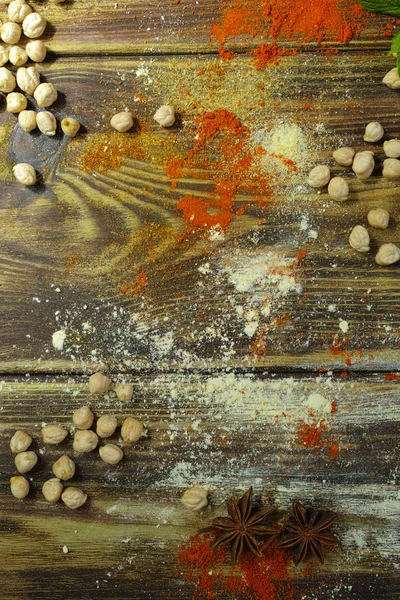 Fondo colorido de los alimentos - garbanzos y especias en madera texturizada — Foto de Stock